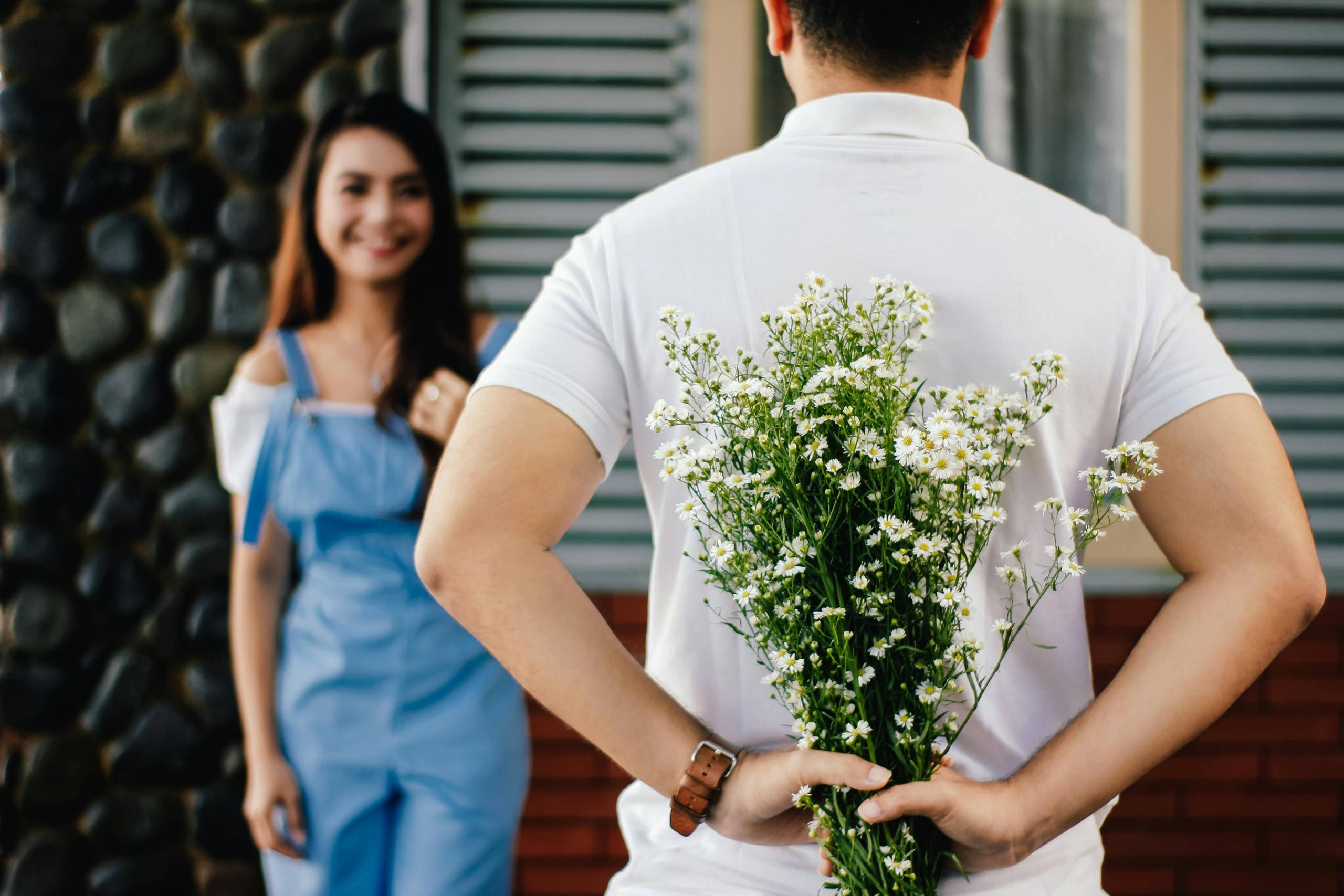 Man about to give flowers to his girlfriend